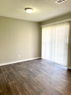 an empty living room with wood floors and a large window